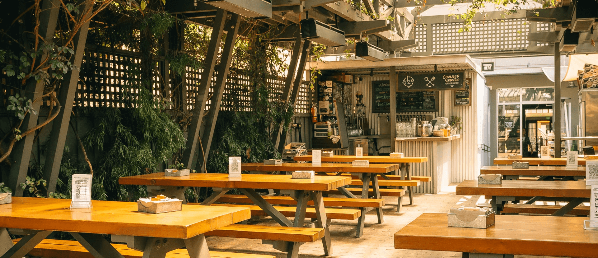 Covered outdoor beer garden with picnic tables at Alvarado Street Brewery & Grill in Monterey, CA