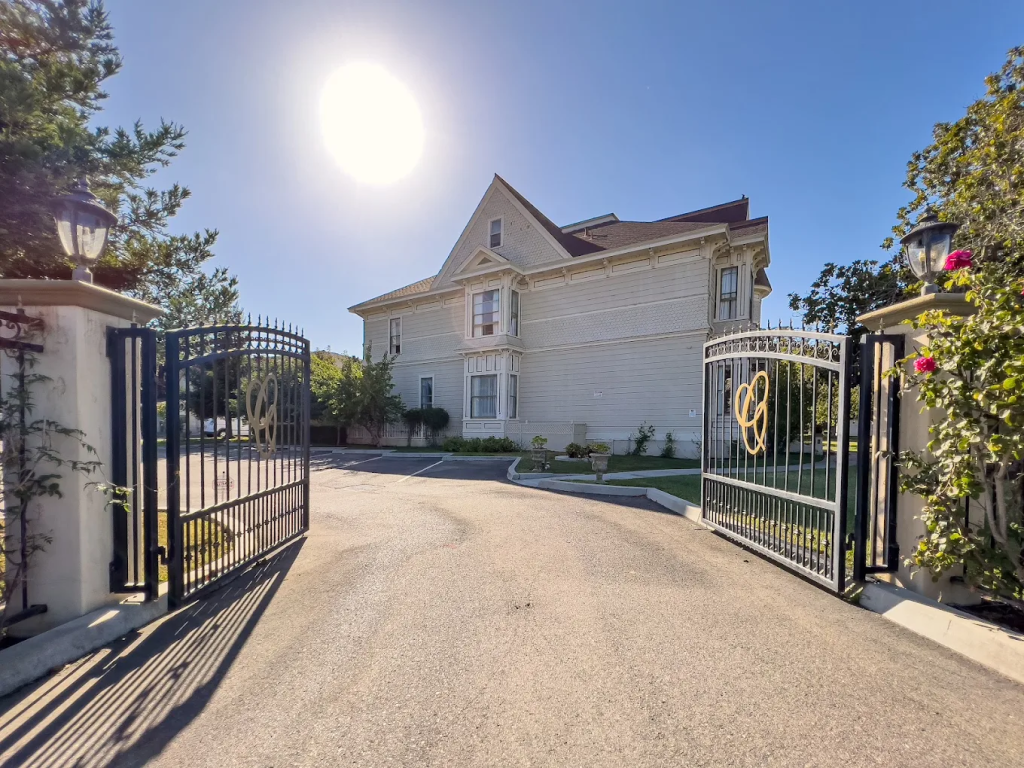 Exterior of Chateau Coralini Salinas hotel, a white, historic building with an open gate