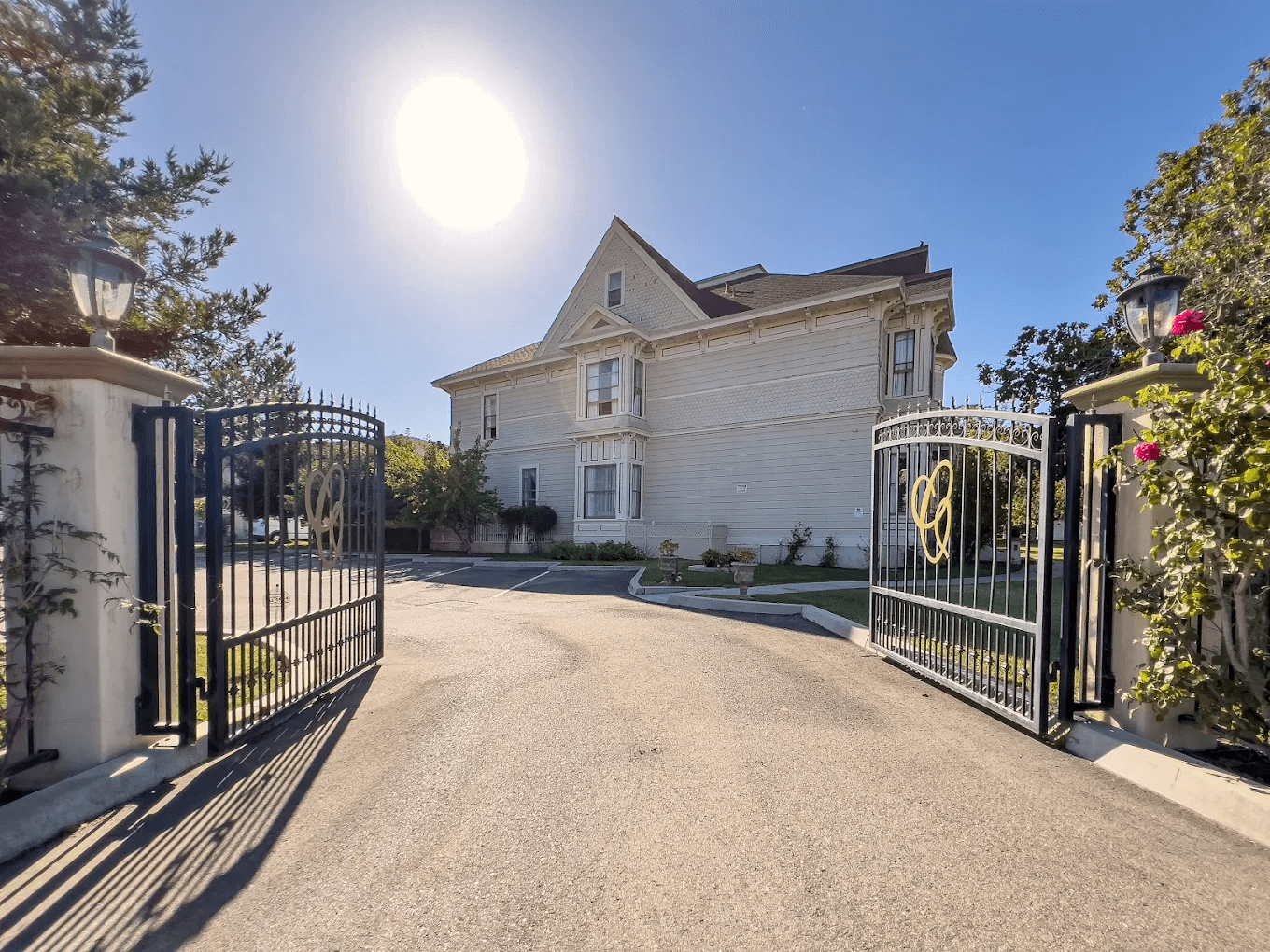 Exterior of Chateau Coralini Salinas hotel, a white, historic building with an open gate