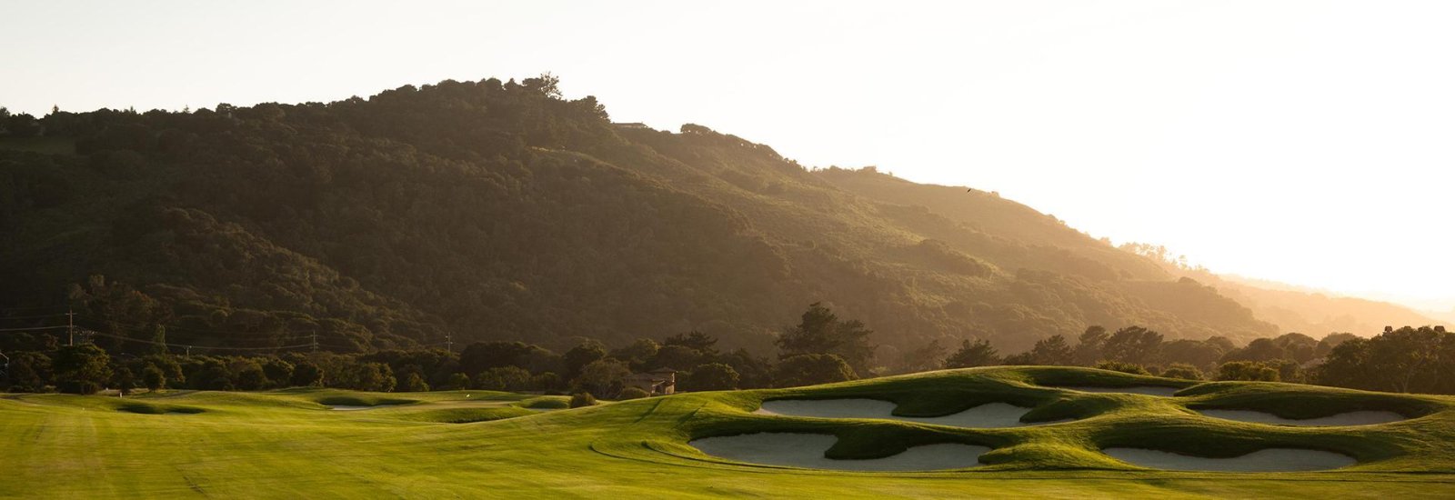 What's New Summer 2025 Golf course greens in front of mountain at TPC at Monterey Pasadera