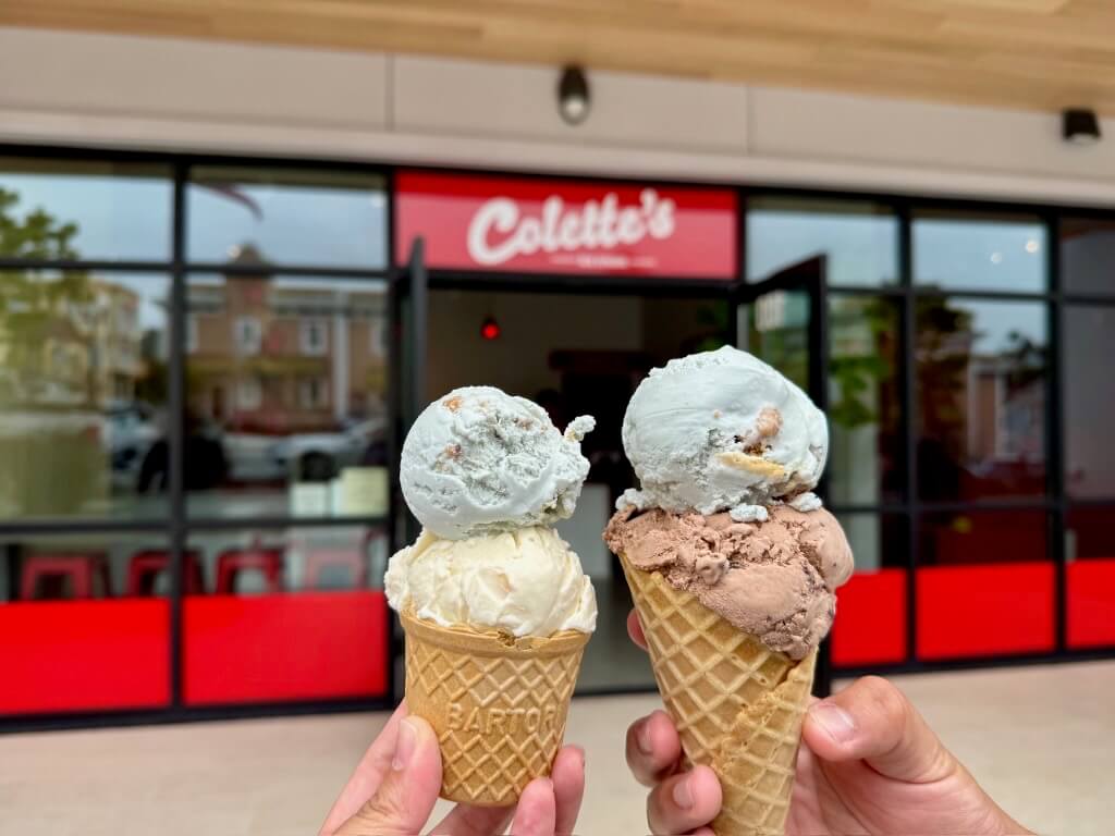 What's New Summer 2025 Two double scoop ice cream cones being held in front of the exterior of Colette's Ice Cream in Pacific Grove
