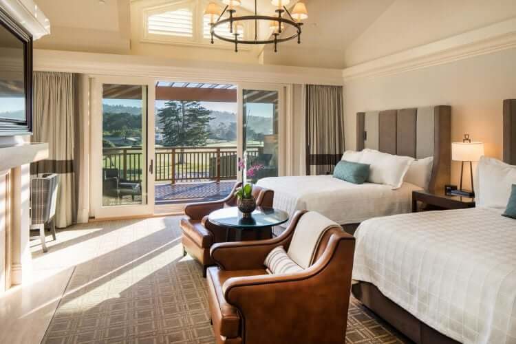 Interior of double queen room at The Lodge at Pebble Beach. Sliding door looks out at the golf course