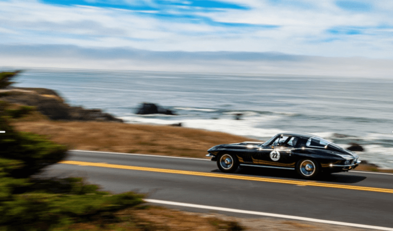 classic car driving along the coast