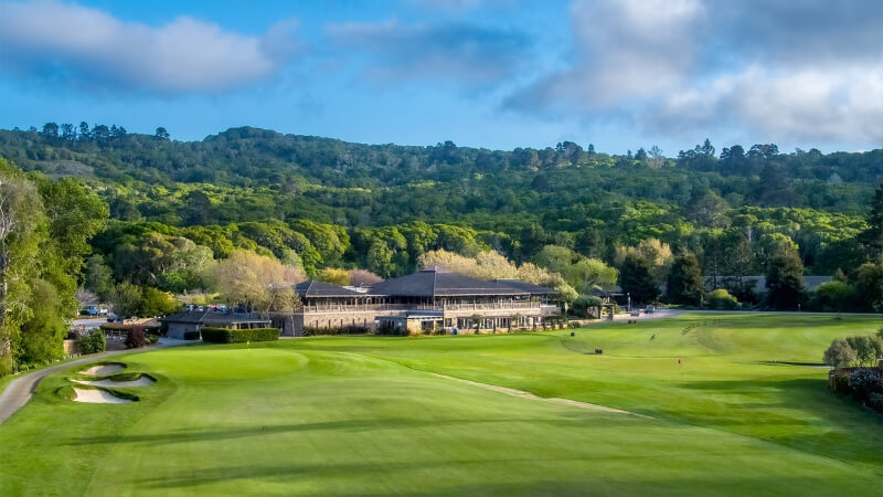 Golf greens with The Quail golf club and trees in the background